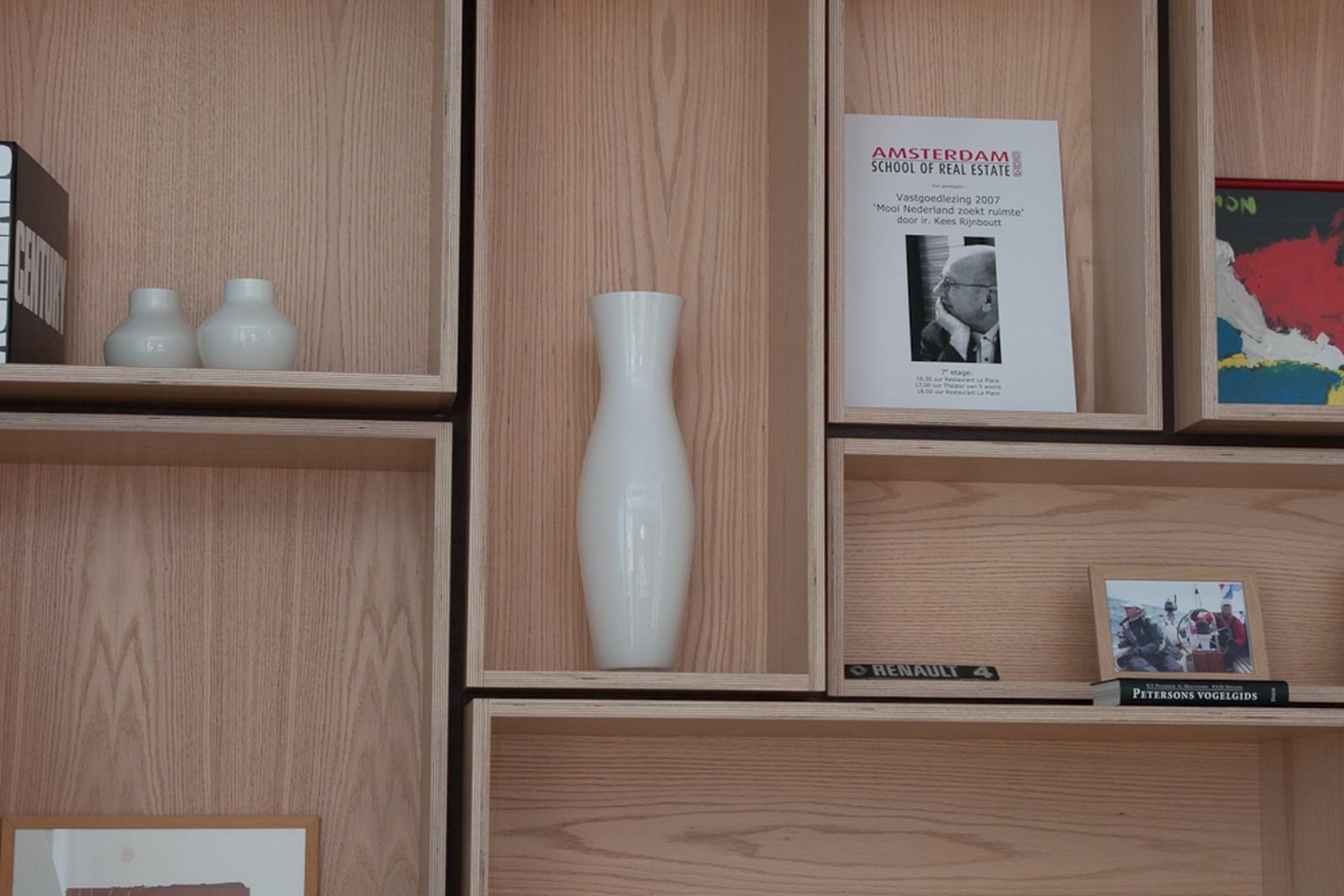 Witte vazen en een uitnodiging in open eiken vakken.