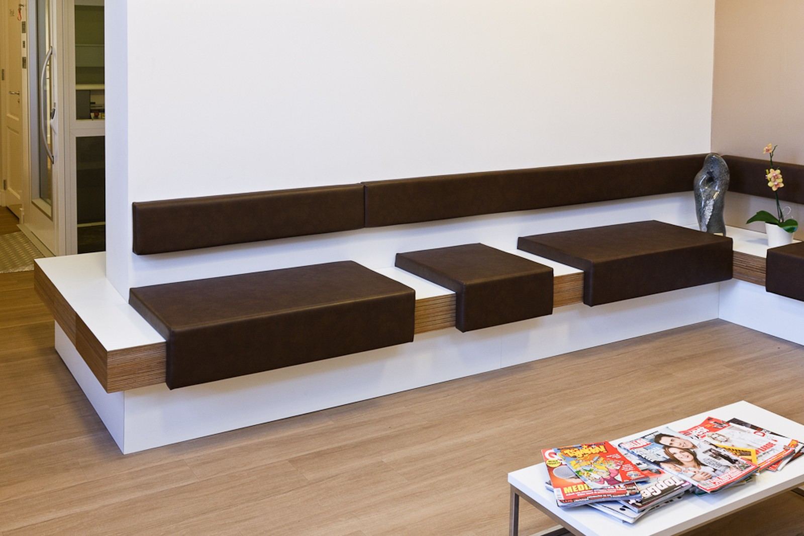 Wachtbank met losse, zwevende zitblokken bekleed met kunstleer.