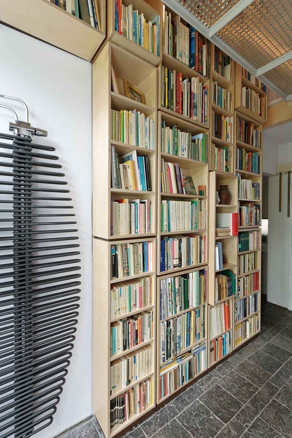 Boekenkast met een raster van vakken tegen de schuine wand.