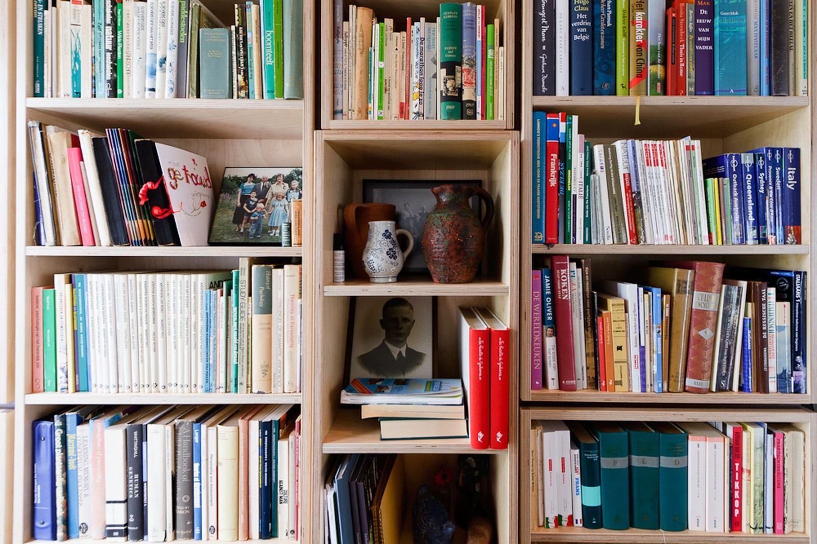 Detail van vakken met boeken en decoratieve voorwerpen op de open planken.