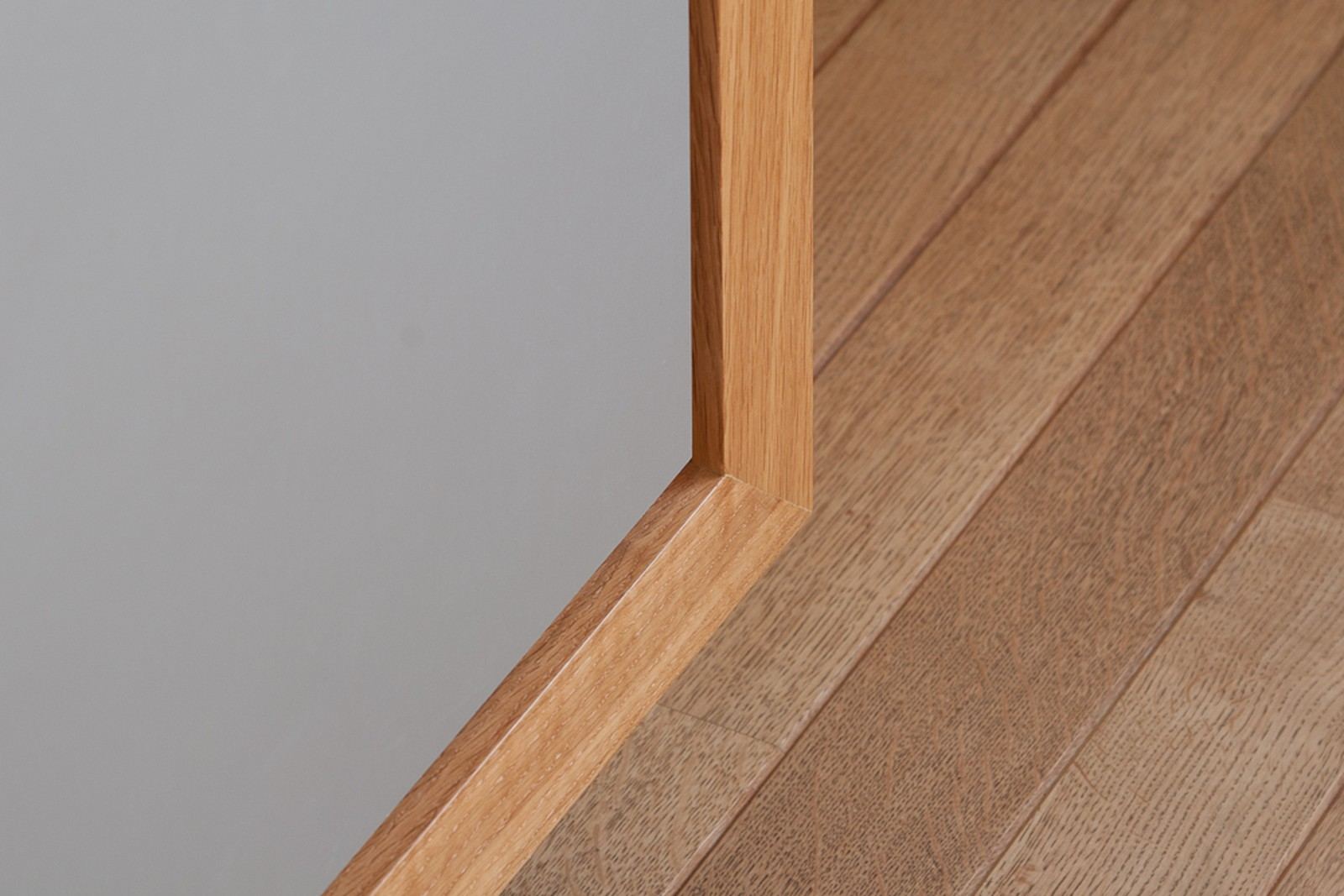 Detail van de eiken hoekverbinding van het dressoir bij de vloer.