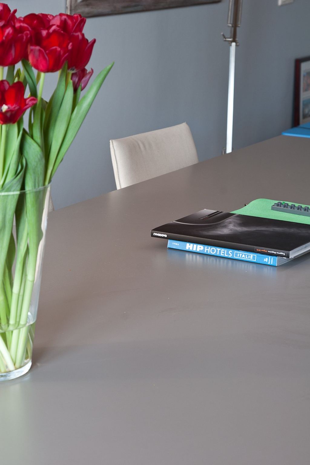 Rode tulpen en boeken op het grijze tafelblad.