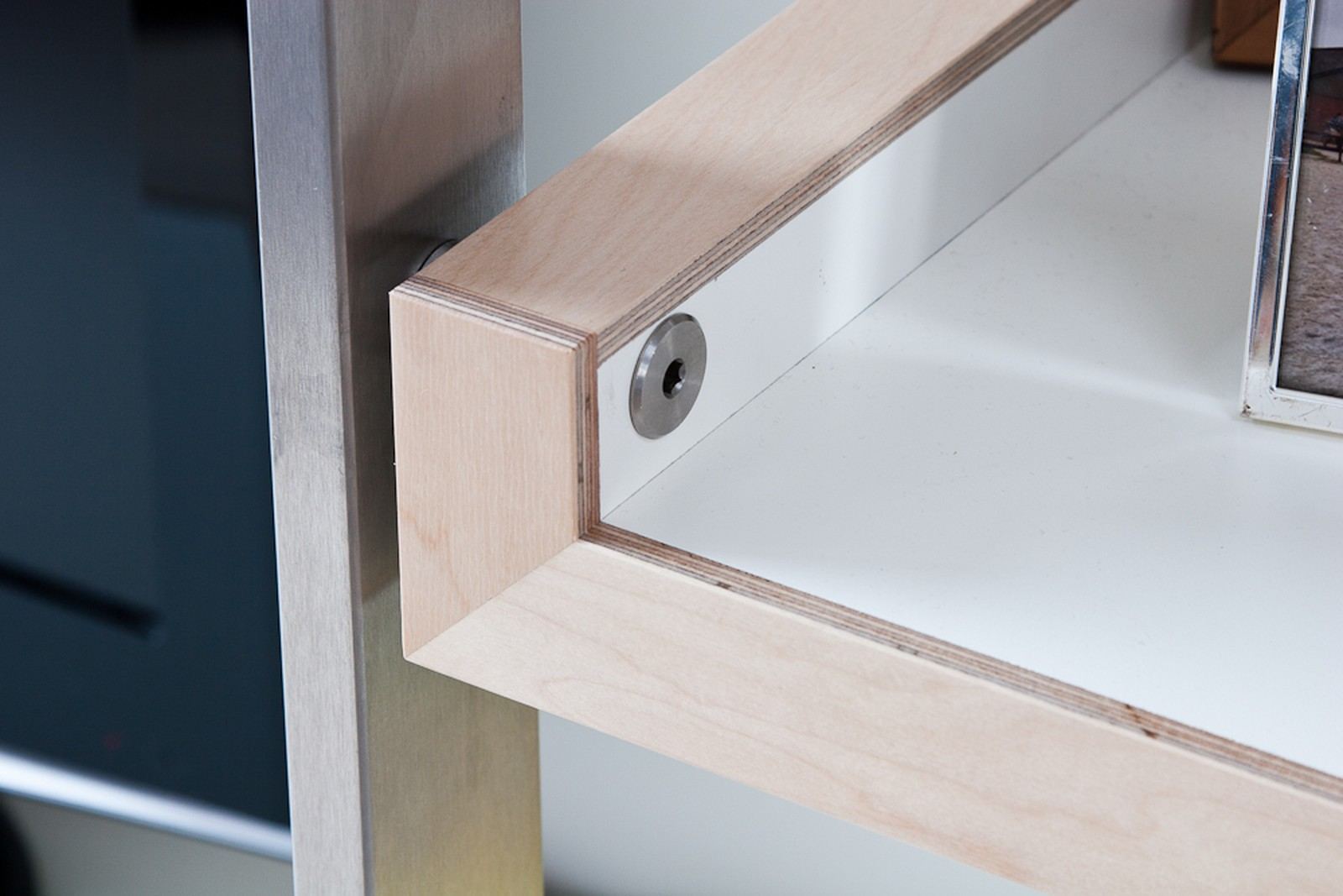 Detail van een houten planklegger met een zichtbare stalen bevestigingsbout.