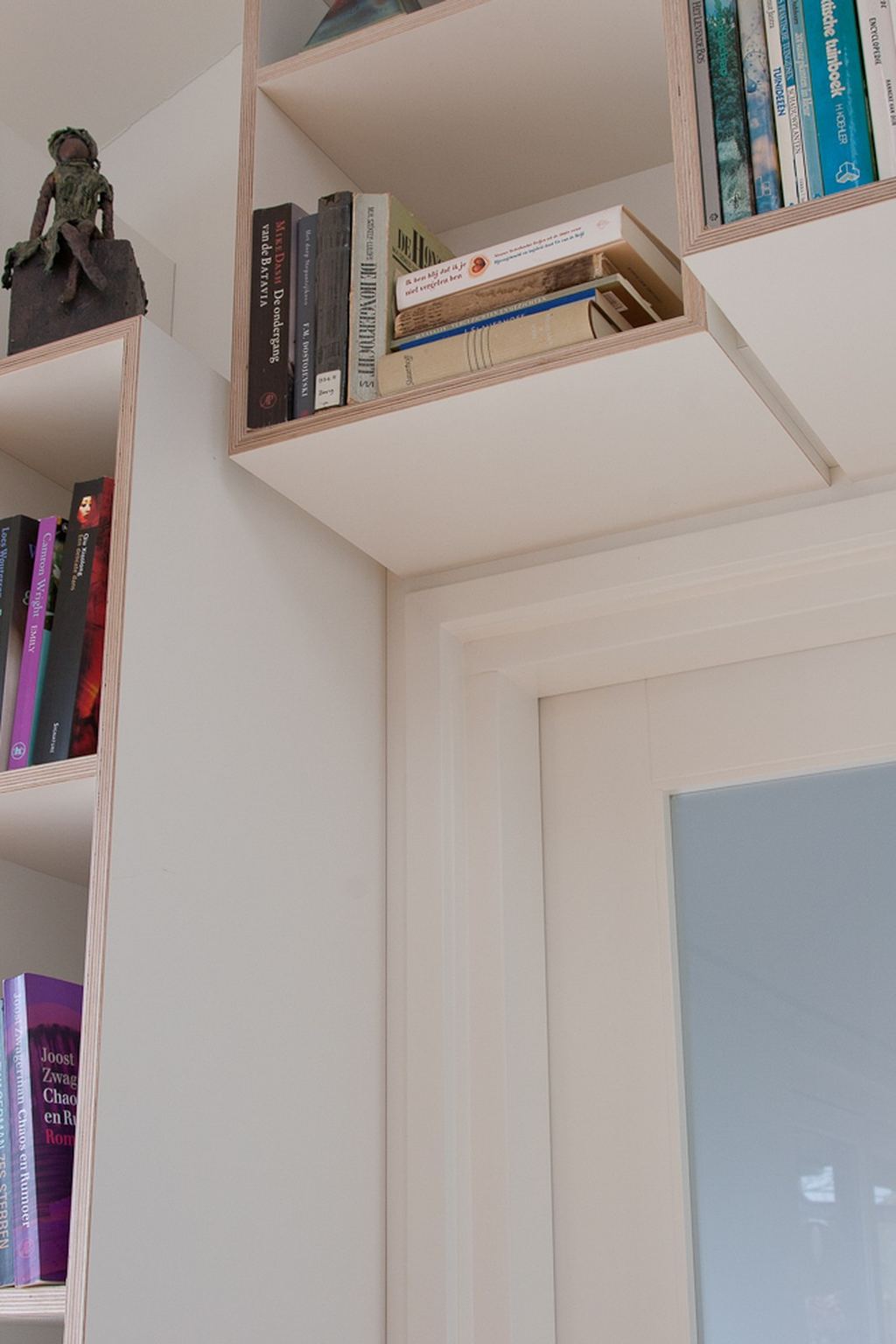 Kastvak boven een deurkozijn, gevuld met boeken.