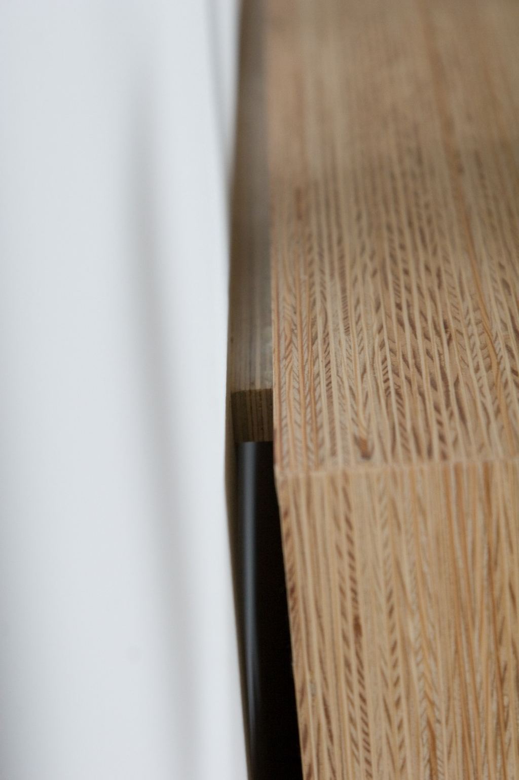 Detail van de gestreepte houtnerf van de plexwood boekenkast.