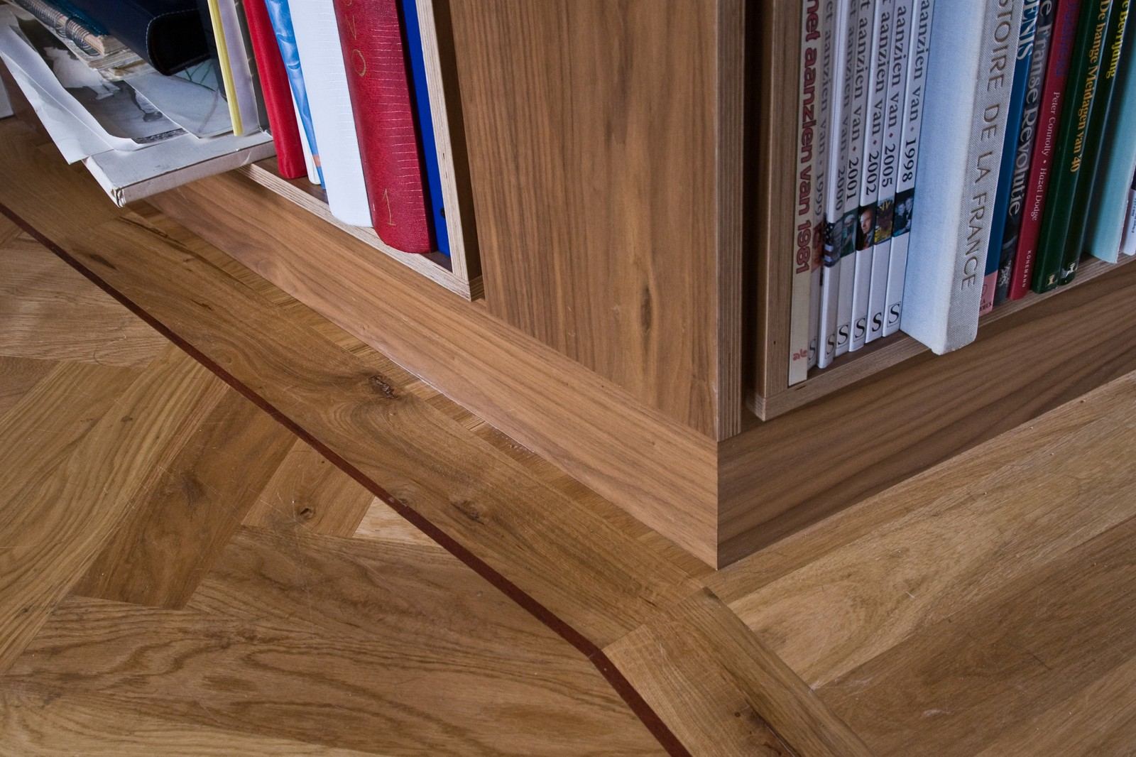 Detail van de onderkant van de boekenkast bij de vloer.