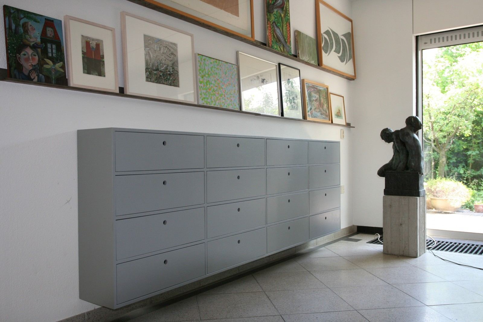 Ondiep grijs dressoir met een raster van kleine lades.