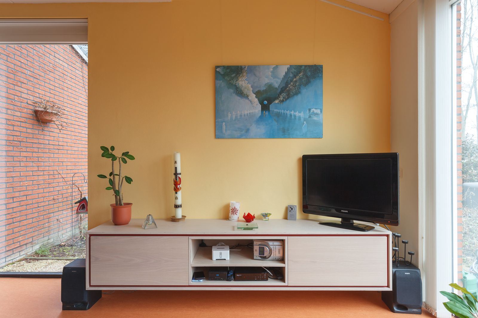 Televisiekast met rode rand en een open middenvak voor apparatuur.