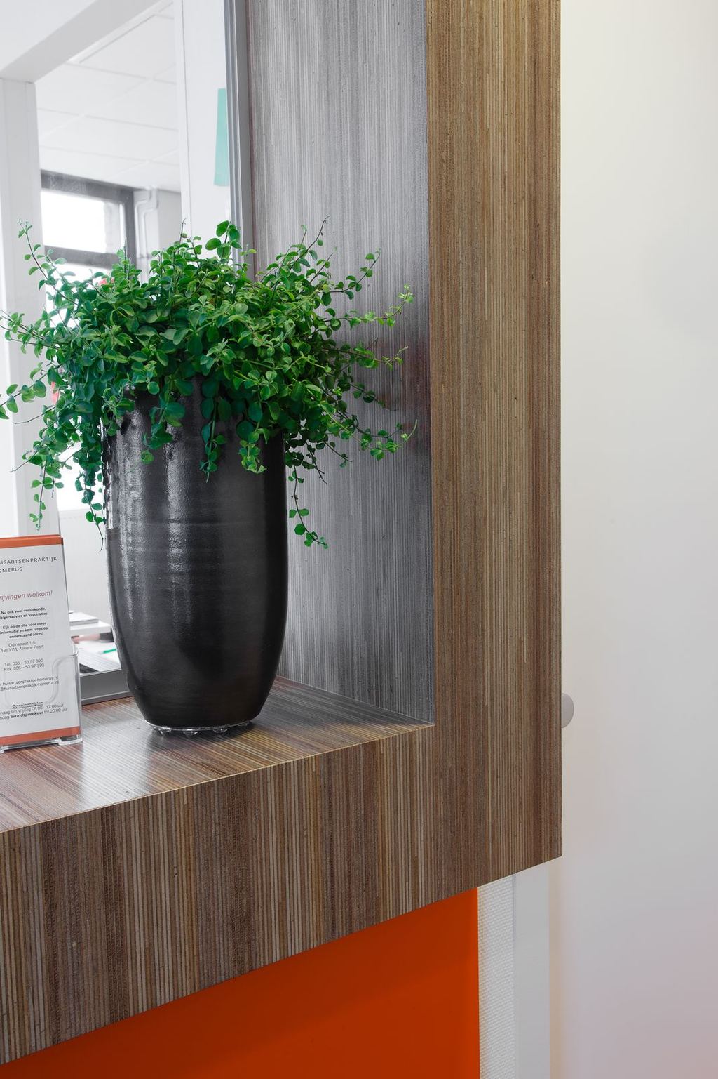 Detail van de balie, met een raamnis afgewerkt in meranti plexwood.