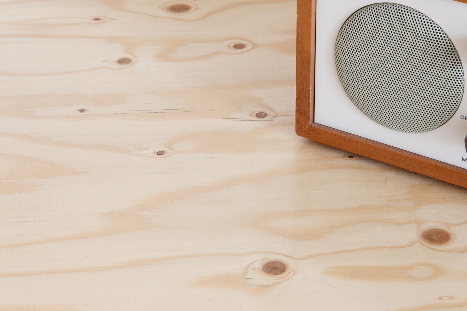 Houten bovenblad van een kast, met een radiospeaker in de hoek.