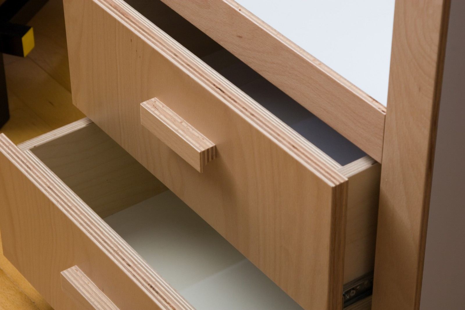 Detail van twee open lades met zichtbare fineerranden.