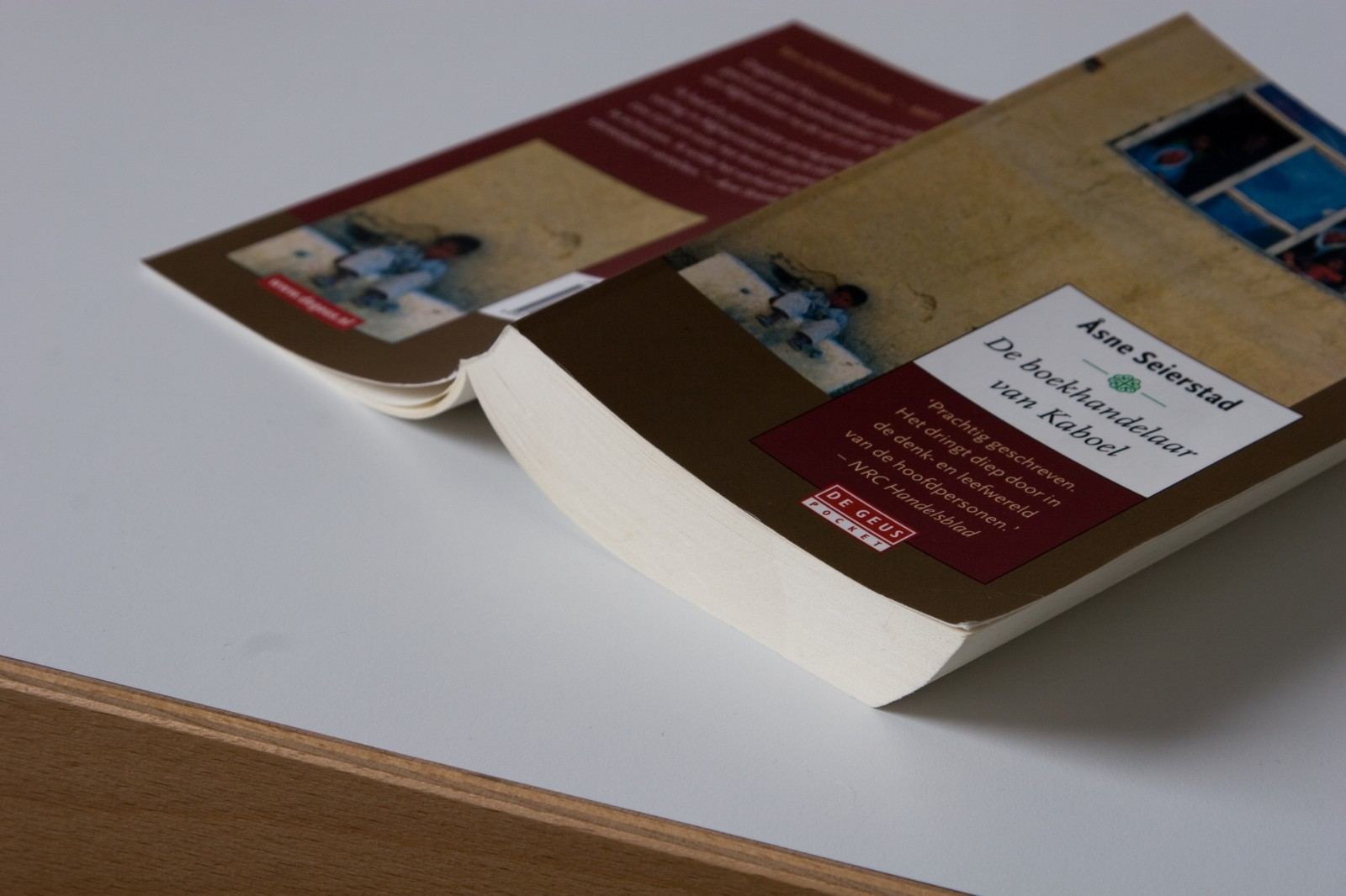 Rand van het bureau waar het witte blad de houten kant ontmoet.