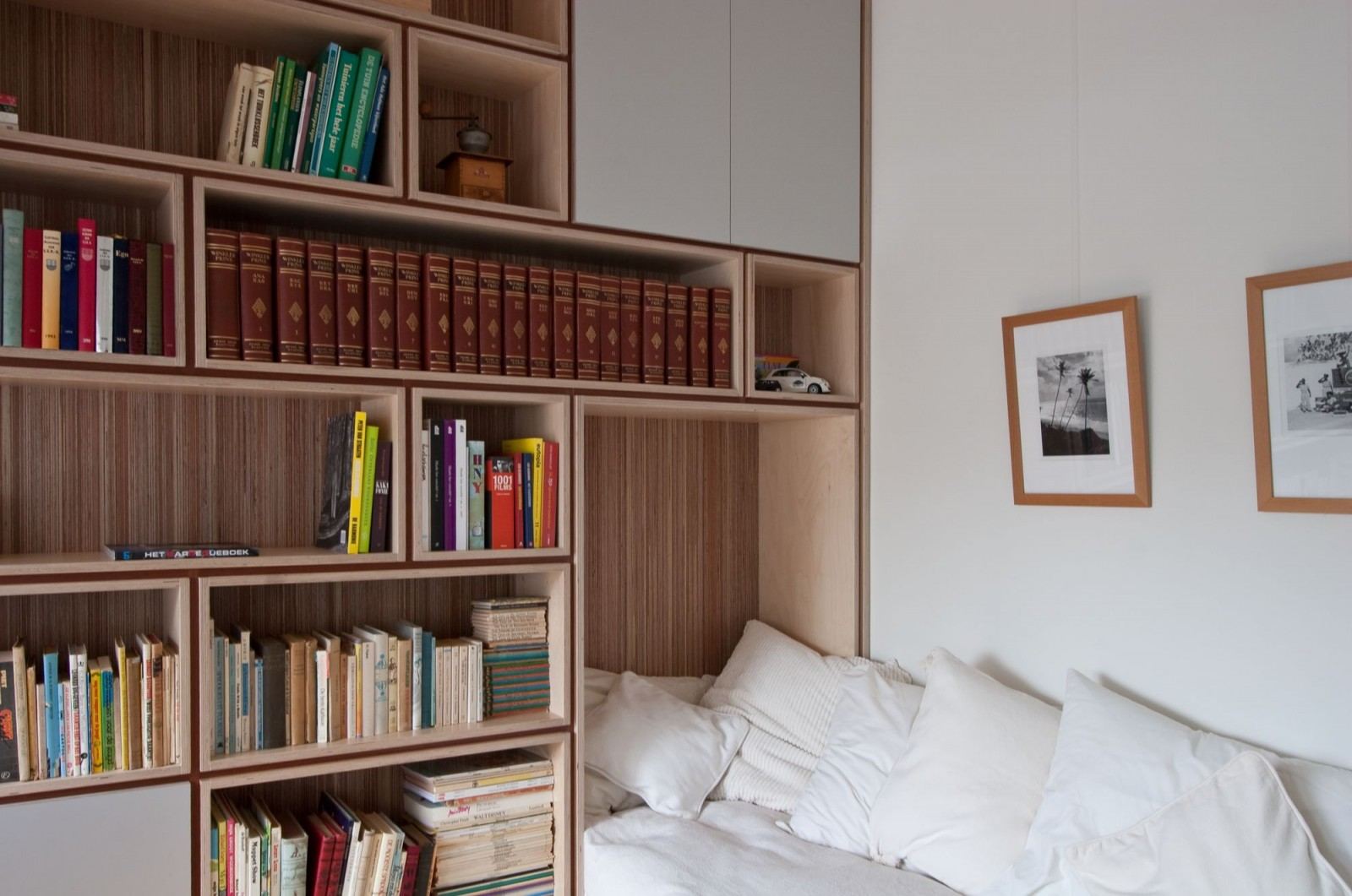 Boekenkast met een encyclopedieset naast het bed in plexwood.