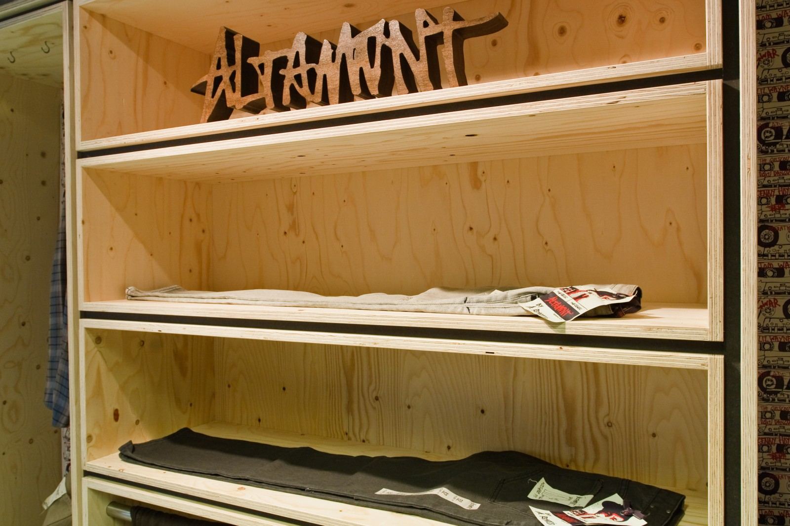 Open vuren multiplex vakkenkast, onderverdeeld met dunne zwarte stroken.
