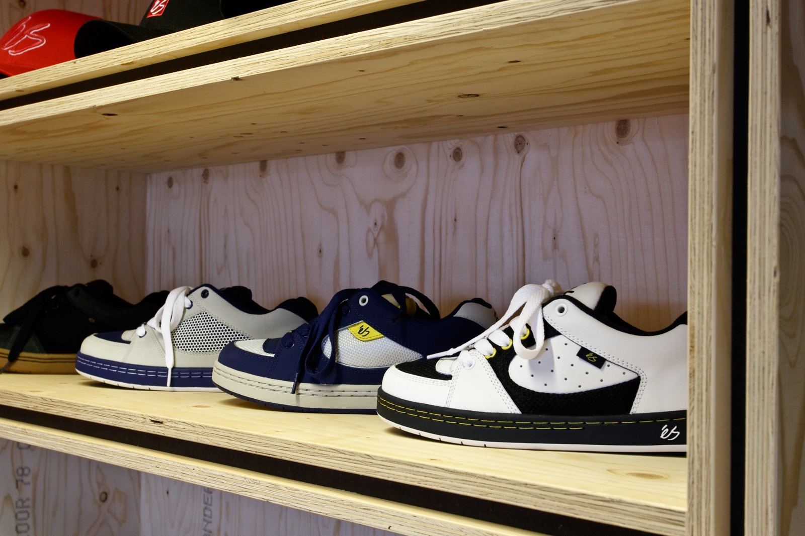 Lange vuren multiplex legplank met een rij sneakers erop.