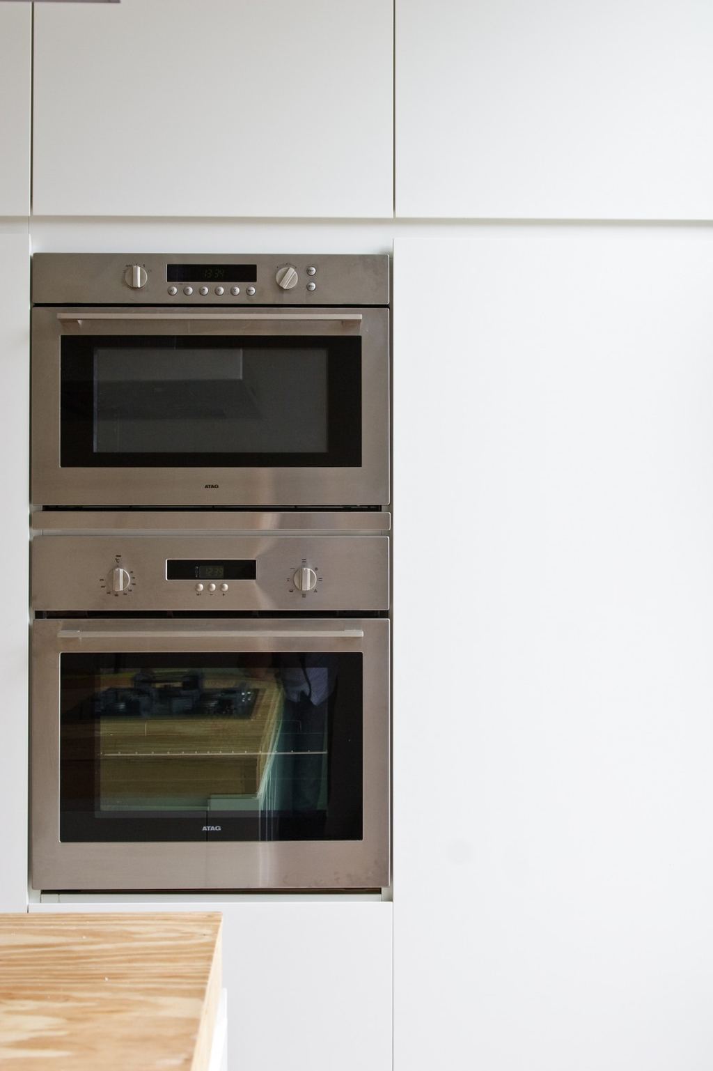 Detail van de ingebouwde dubbele oven in het witte kastfront.