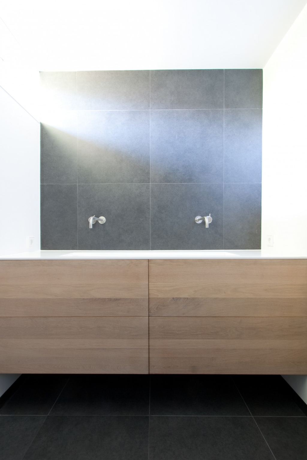 Wastafelmeubel met massief kersen lades onder een corian wastafel.