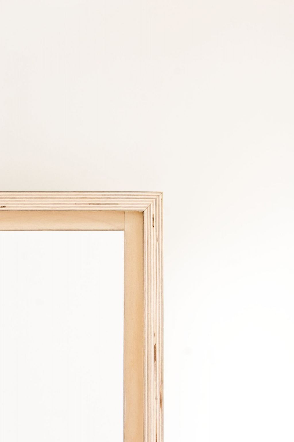 Detail van de berken fineer rand op het witte dressoir.