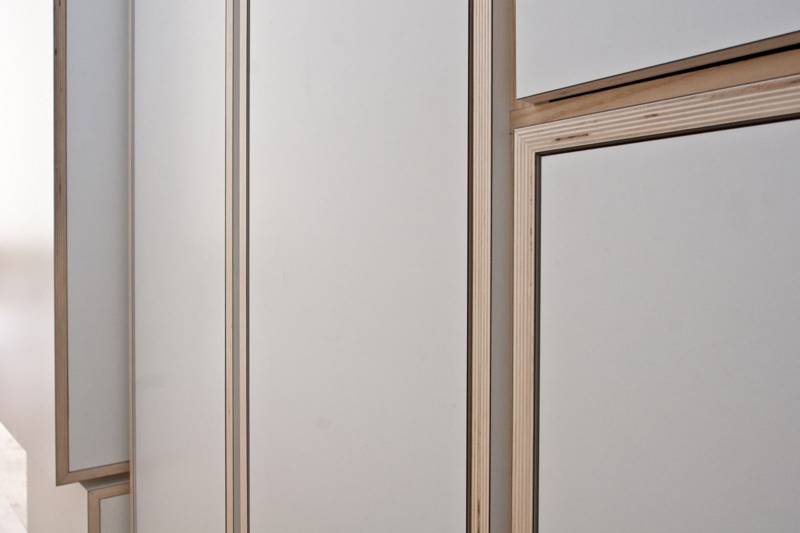 Detail van kastdeuren met een ventilatiesleuf boven een van de deuren.