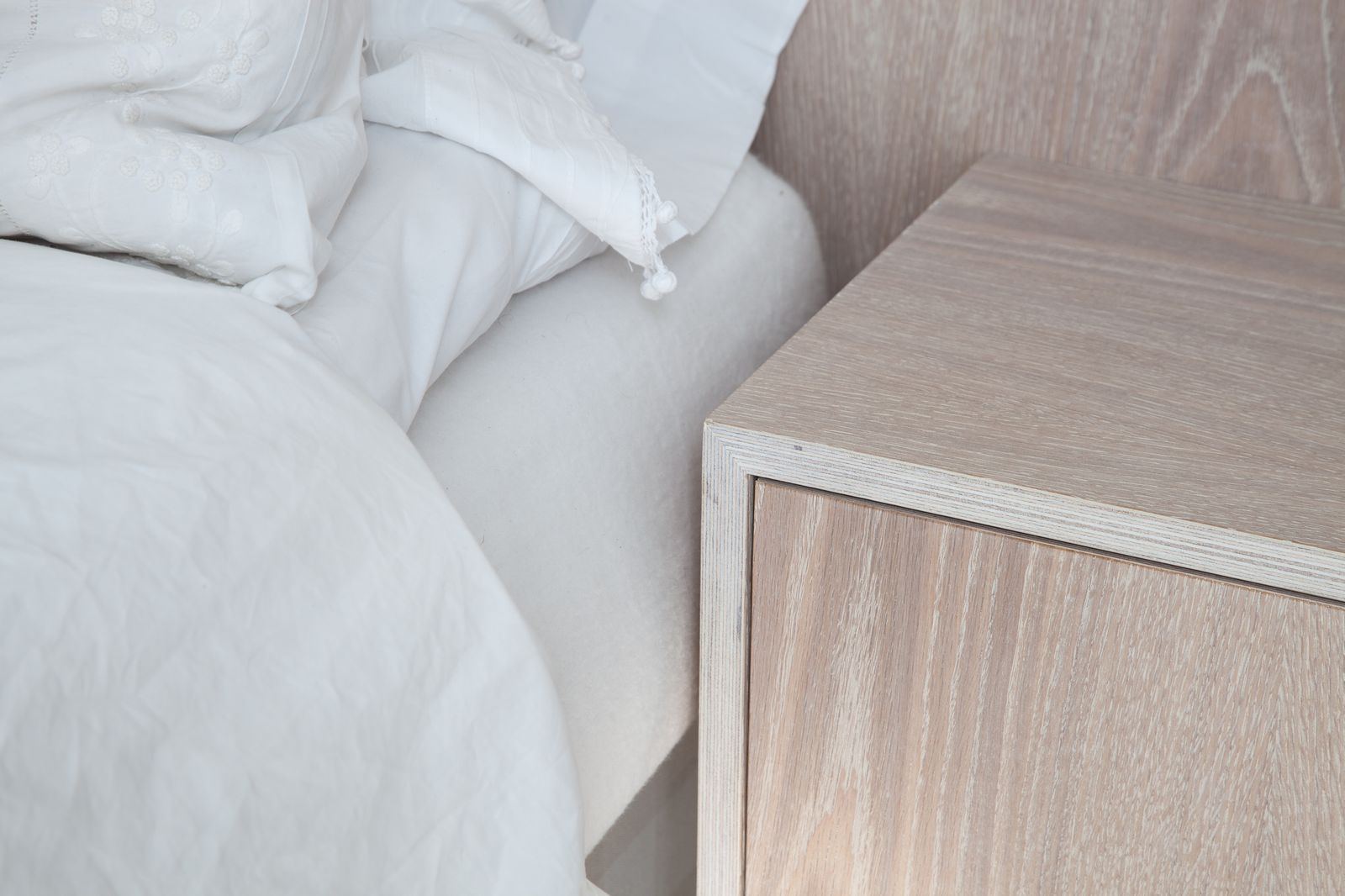 Detail van het zwevende nachtkastje aan het bedhoofd.