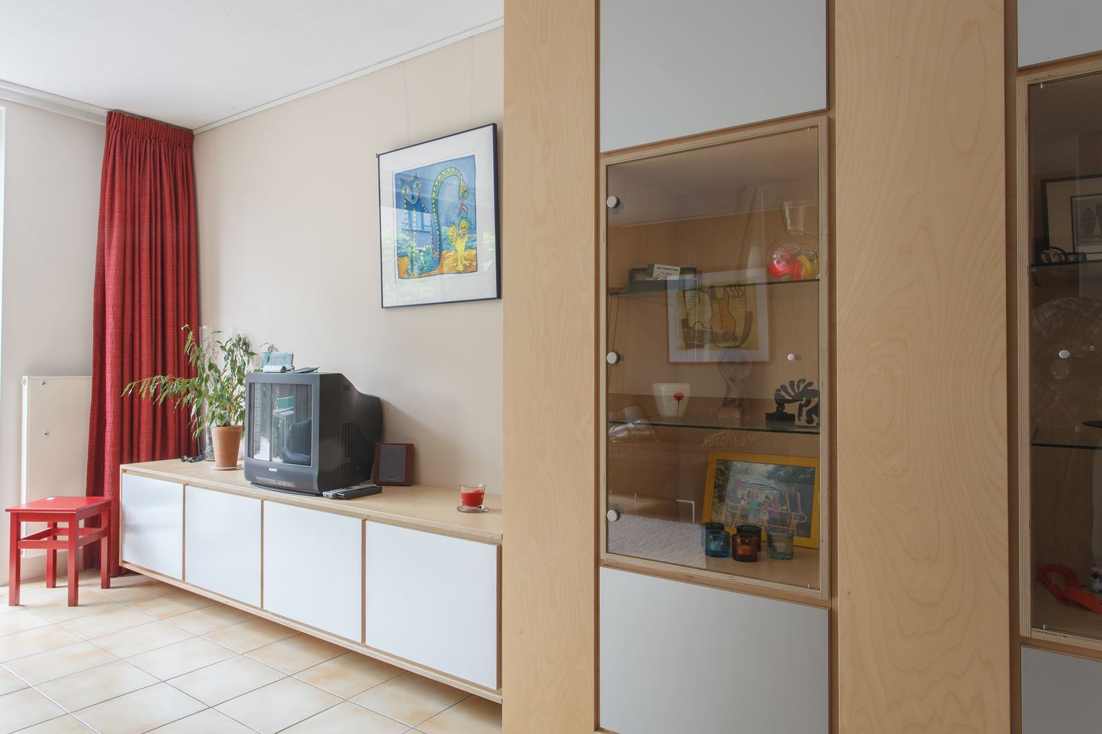 Wandkast met glazen vitrinedeur en een laag dressoir met witte fronten.