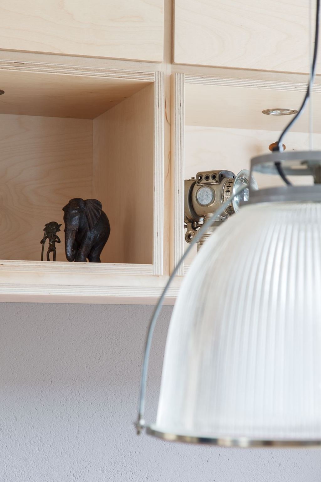 Detail van een display-nis met een olifantje en een aapje, naast een antieke camera.