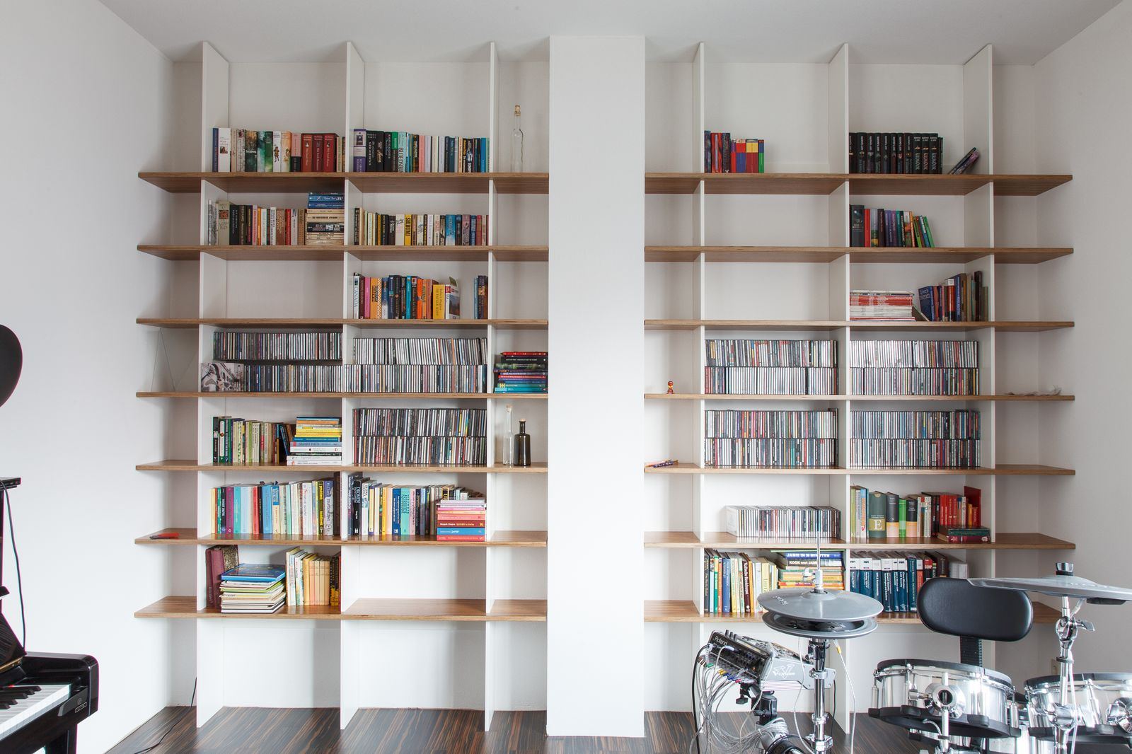 Brede wand met open boekenkasten aan weerszijden van een kolom.