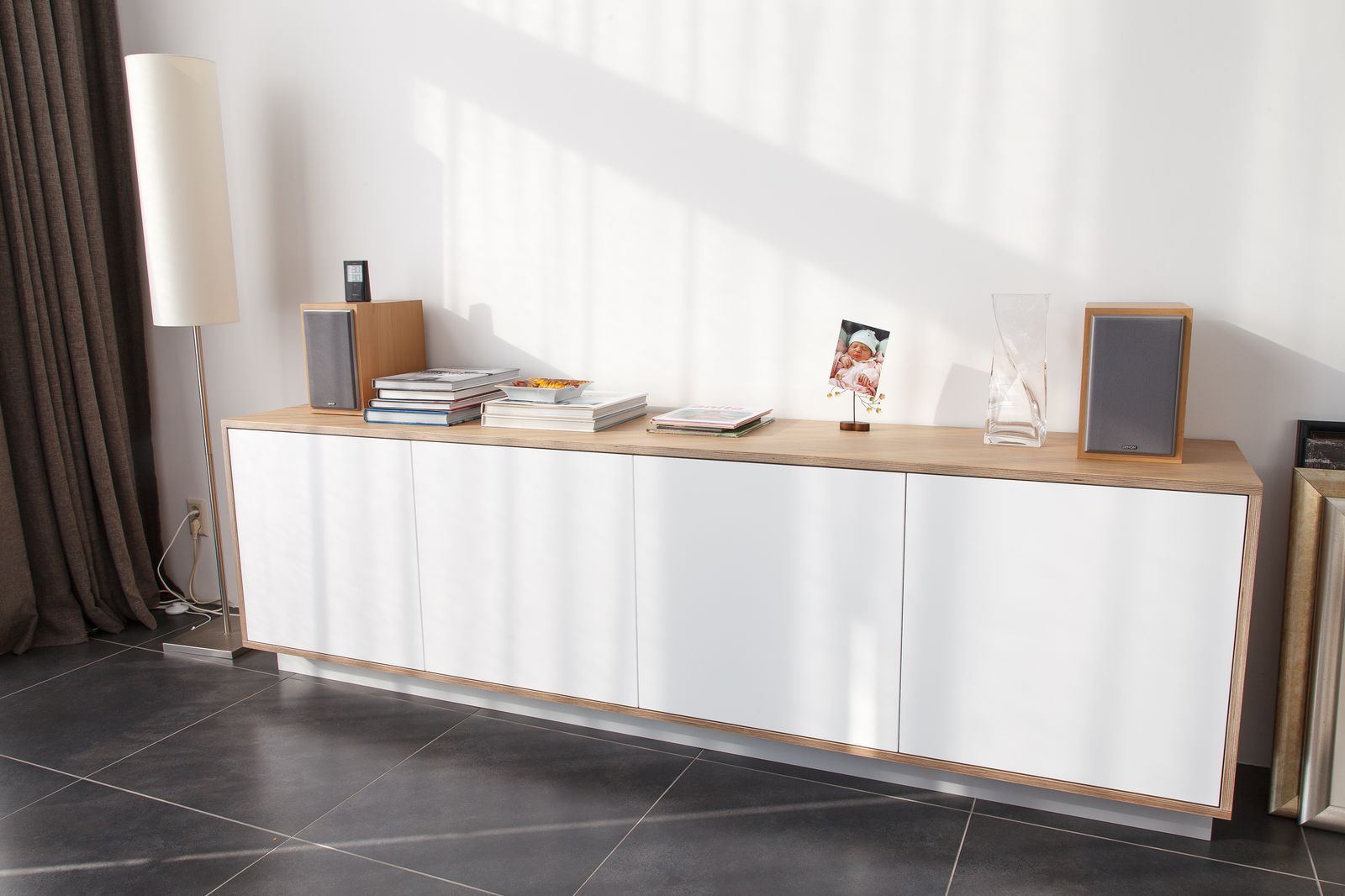 Zwevend dressoir met eiken bovenblad en witte deuren.