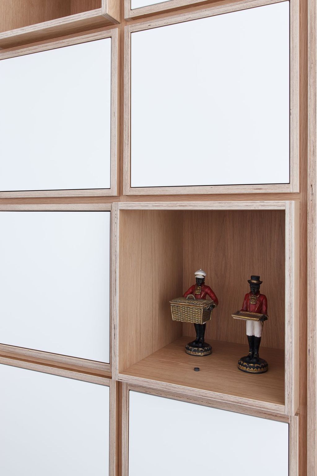 Open vak van de boekenkast met twee kleine beeldjes.