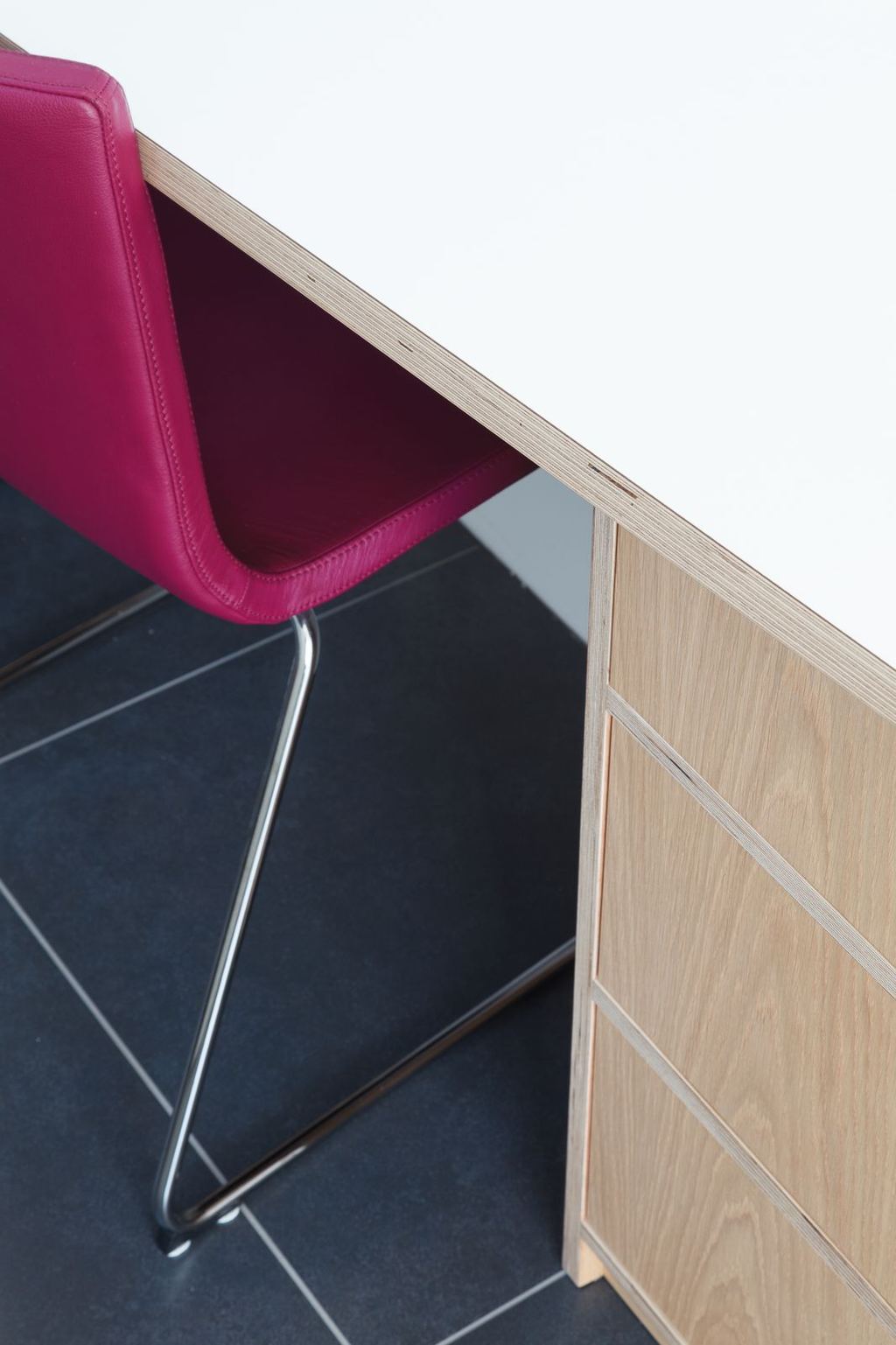 Detail van de hoek van het bureau met ladenkast.