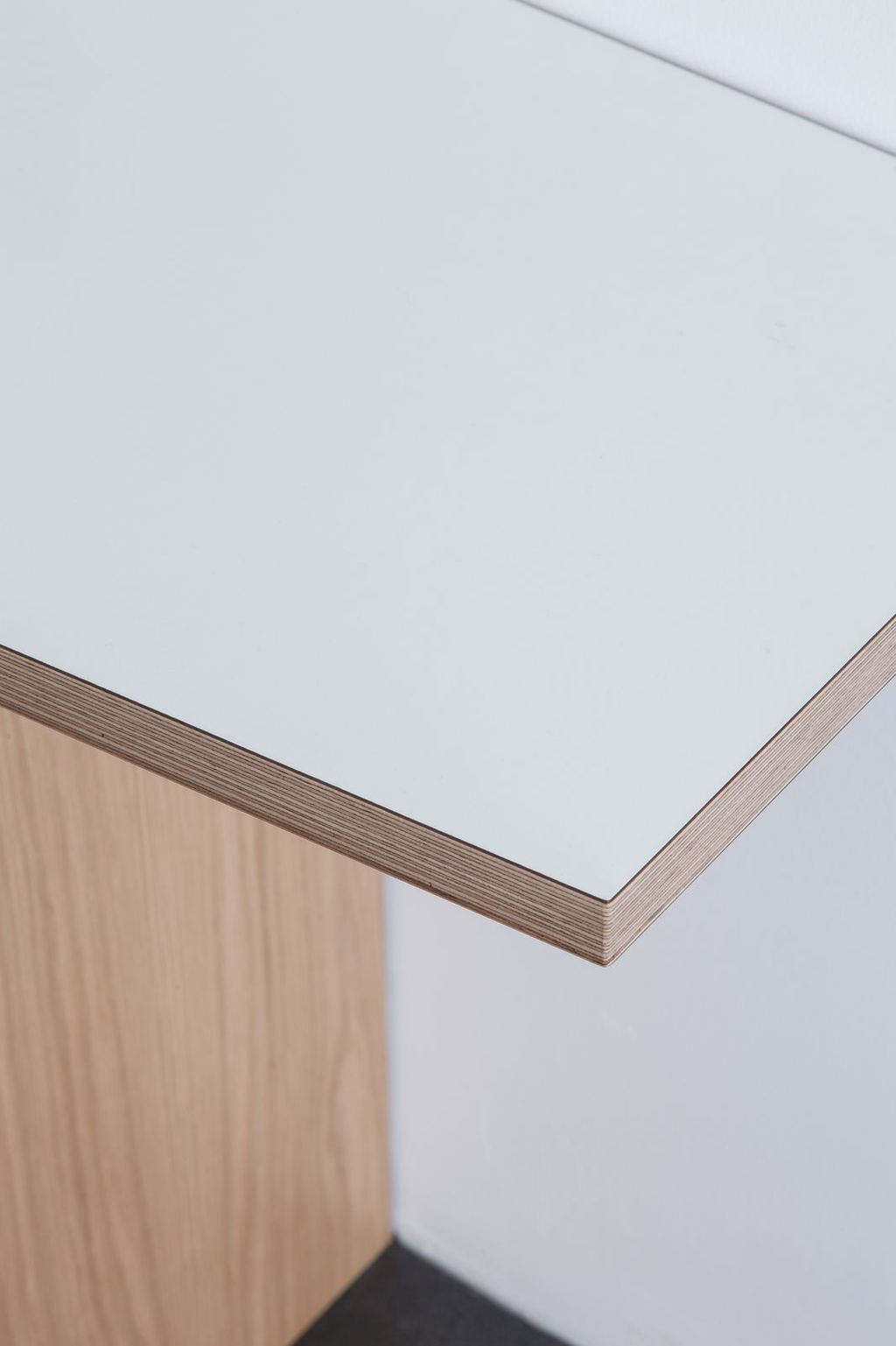 Detail van het witte bureaublad met eiken plaatrand.