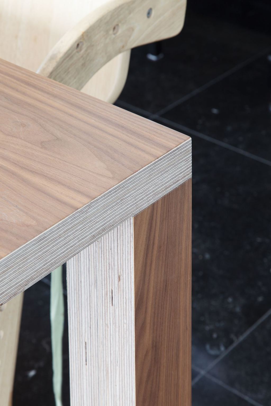 Detail van de hoekverbinding van de eettafel, met zichtbare fineerranden.