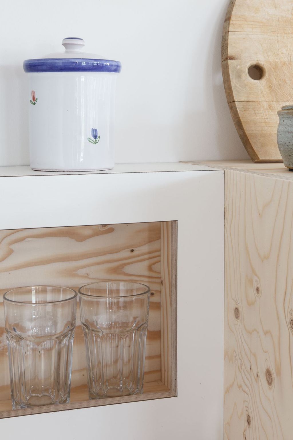 Open kastvak met twee glazen erin, naast een houten zijpaneel.