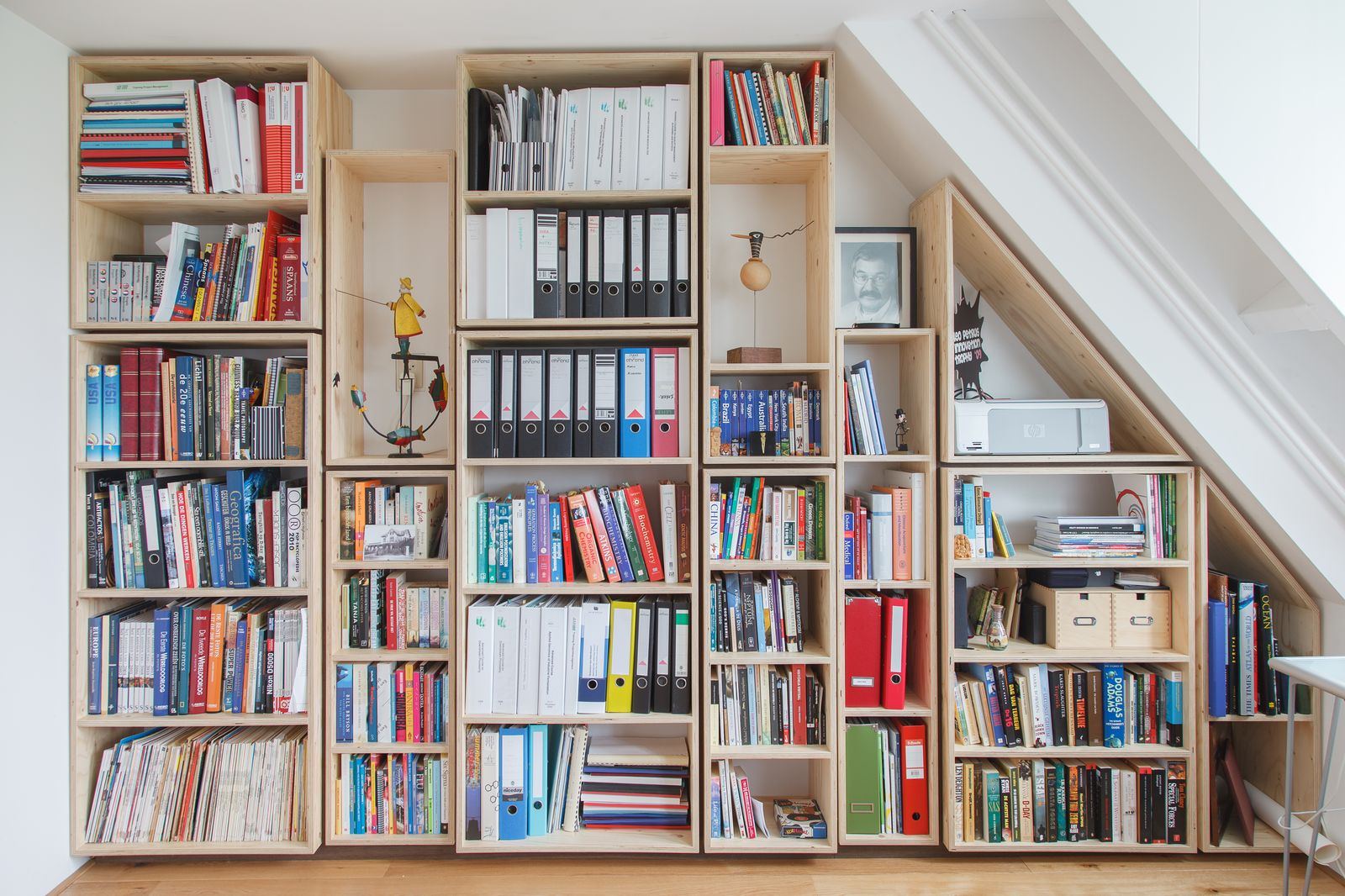 Boekenkast van losstaande, vuren multiplex torens in wisselende hoogtes.