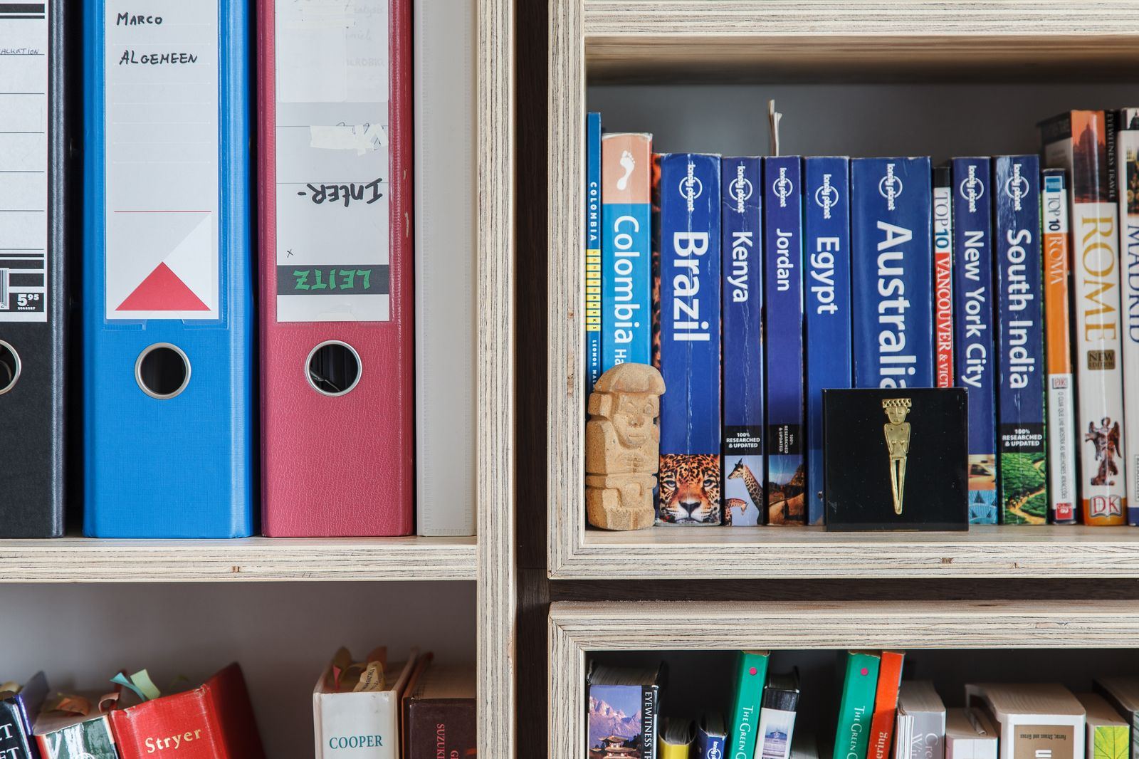Twee vuren multiplex vakken naast elkaar, gevuld met boeken en ordners.