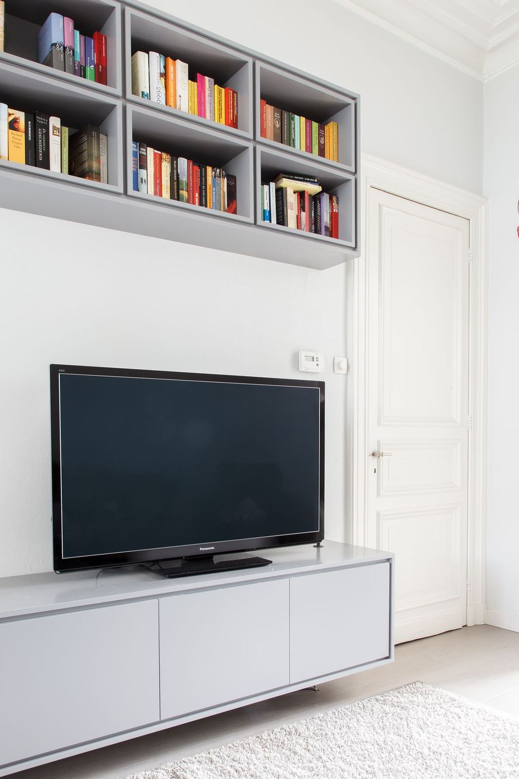Detail van de greeploze deuren van het grijze tv-dressoir.