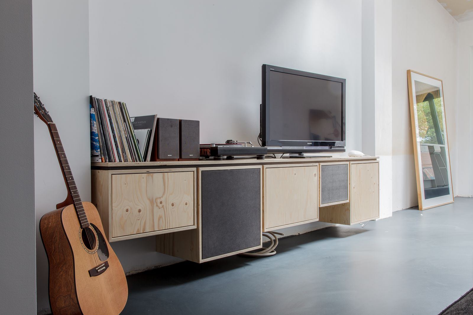 Zwevend dressoir van vuren multiplex met antracieten speakerdoek-fronten.