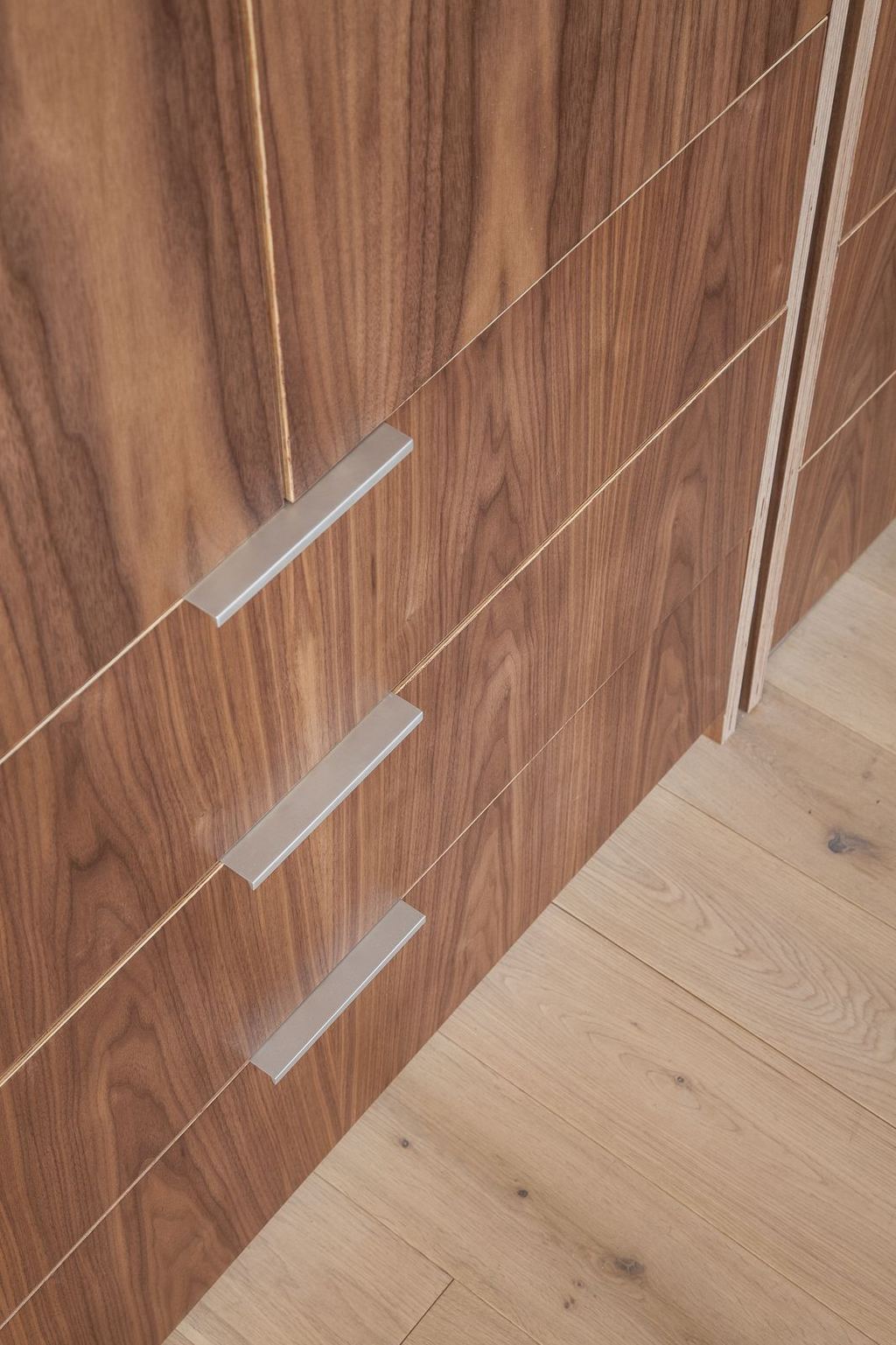 Detail van de notenfineer lades met aluminium ladegrepen.