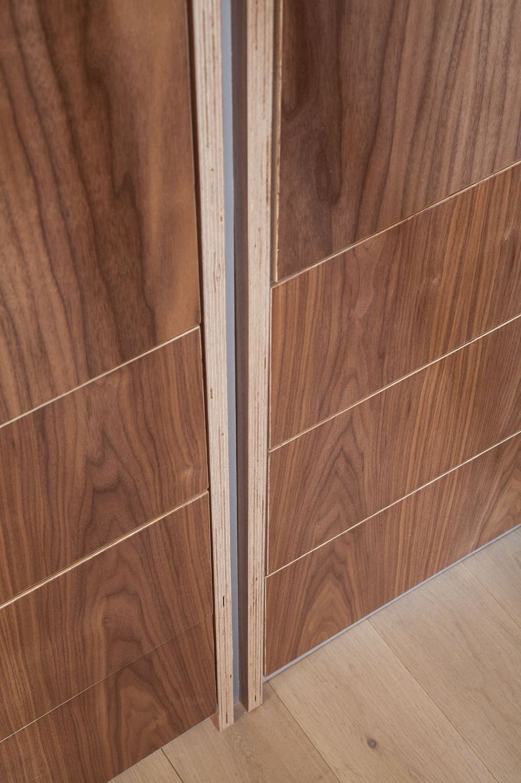 Detail van de aluminium strip tussen twee kastdeuren.