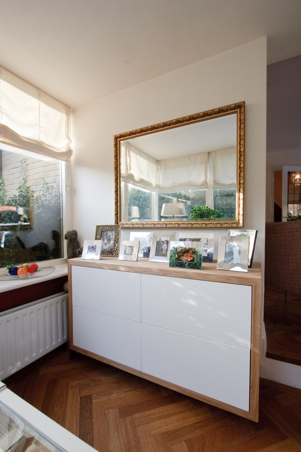 Zwevend dressoir met een houten omlijsting en brede witte laden.