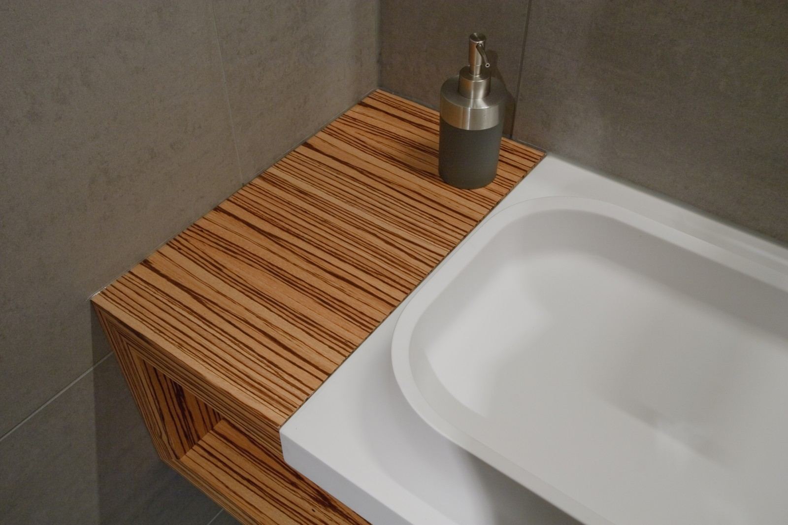 Zwevende houten plank met een open vak vol opgerolde handdoeken.