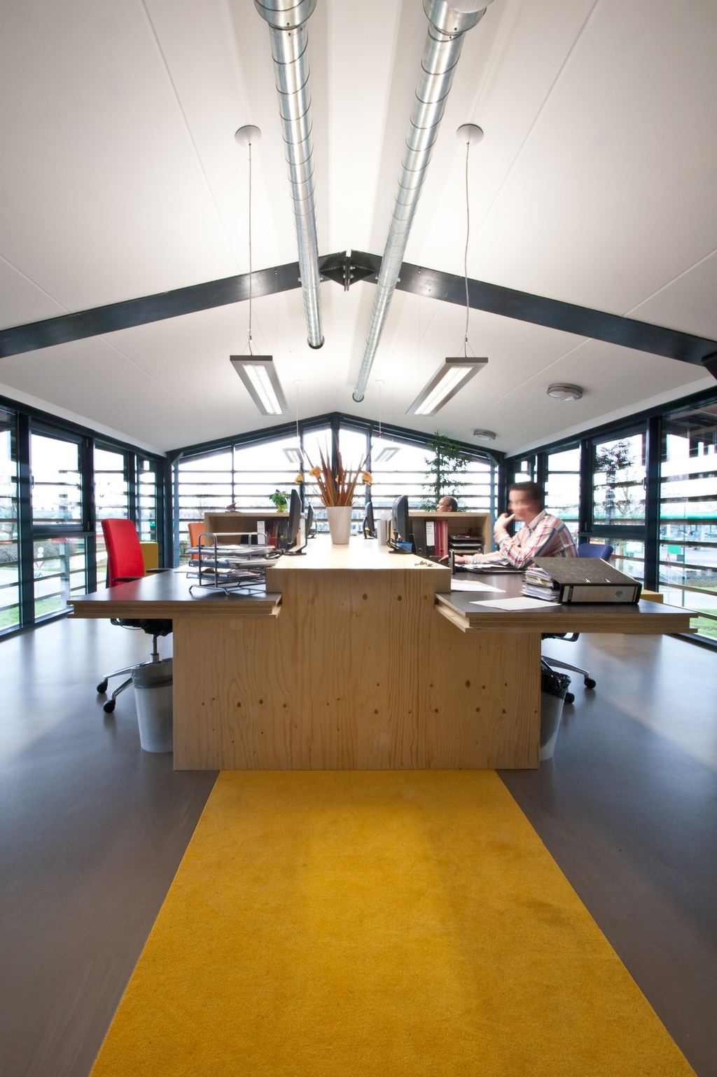 Symmetrisch bureau-eiland met een vuren multiplex kastenwand in het midden.