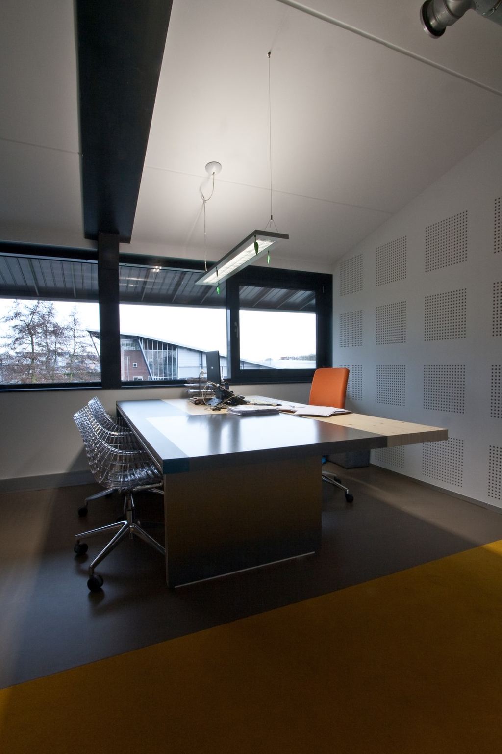 Bureau met zwart werkblad en een uitstekende plank van vuren multiplex.
