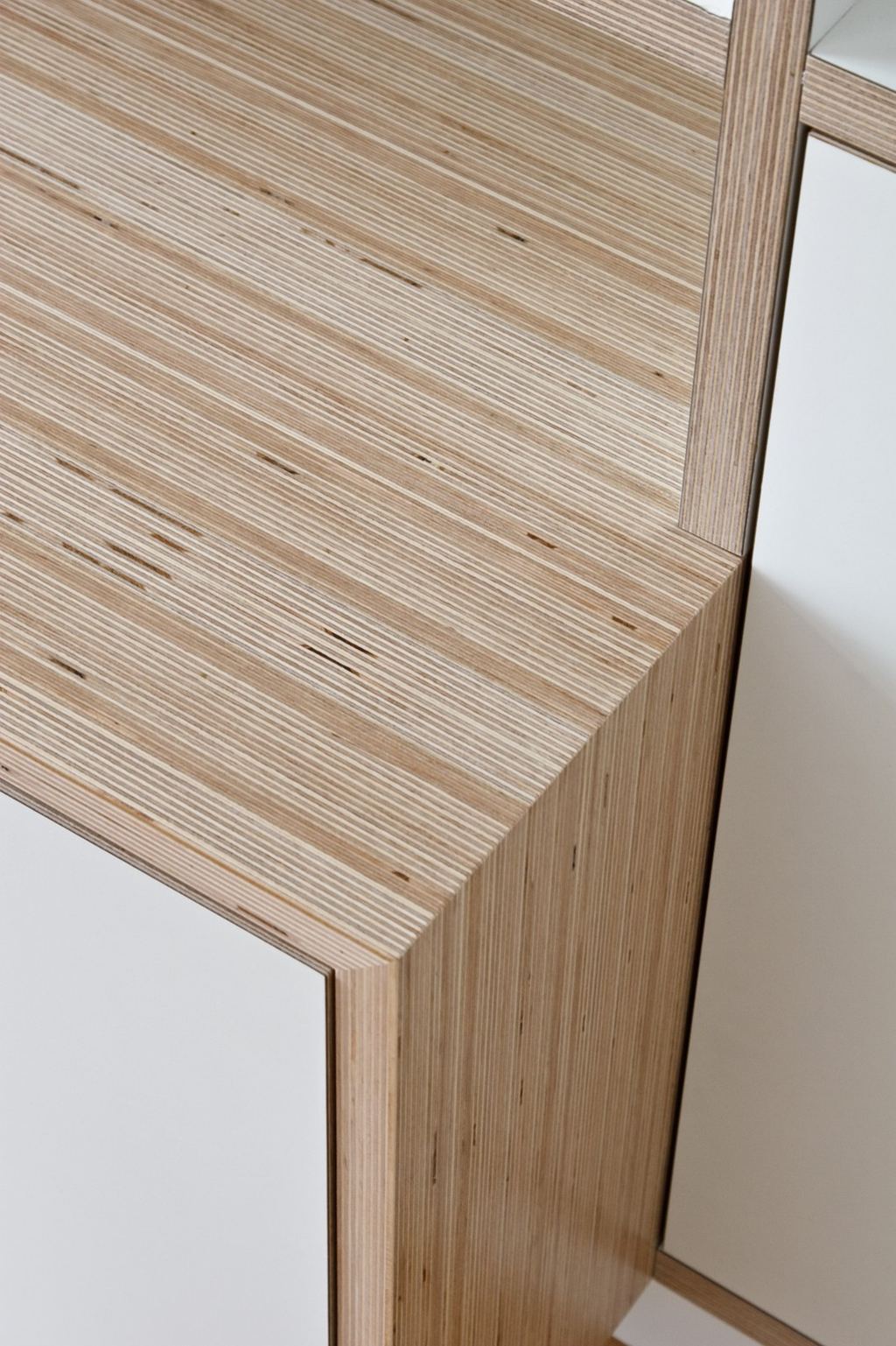 Close-up van de multiplex hoekverbinding tussen witte kastvakken.