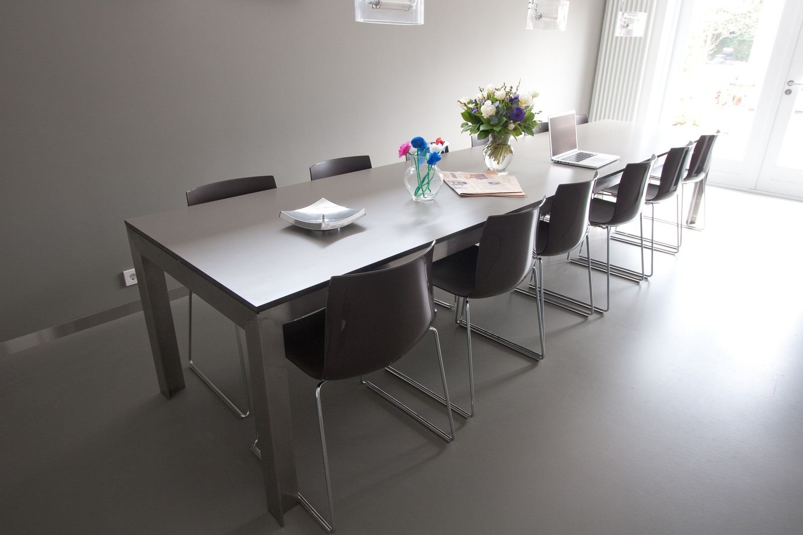 Lange eettafel met een HPL blad op een stalen onderstel.