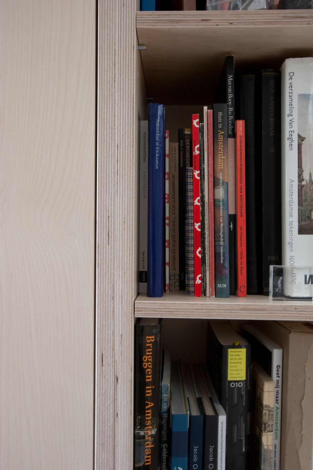 Detail van een plank vol boeken over Amsterdam.