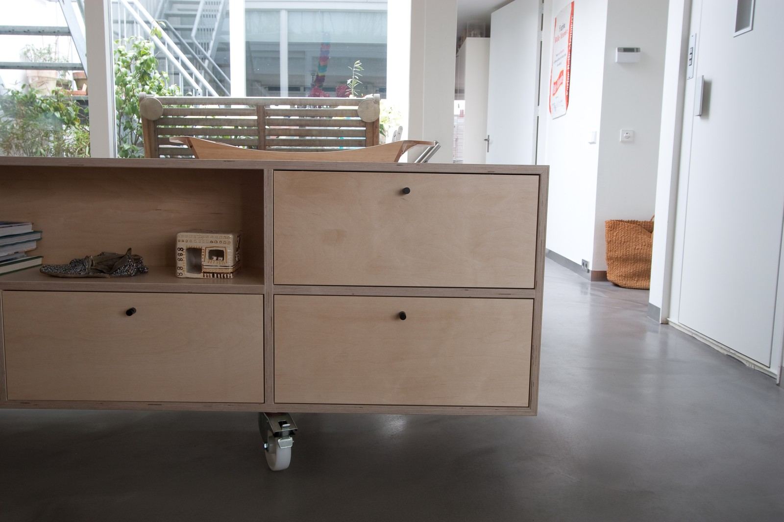 Dressoir op wieltjes met een open vak en meerdere laden met zwarte knoppen.