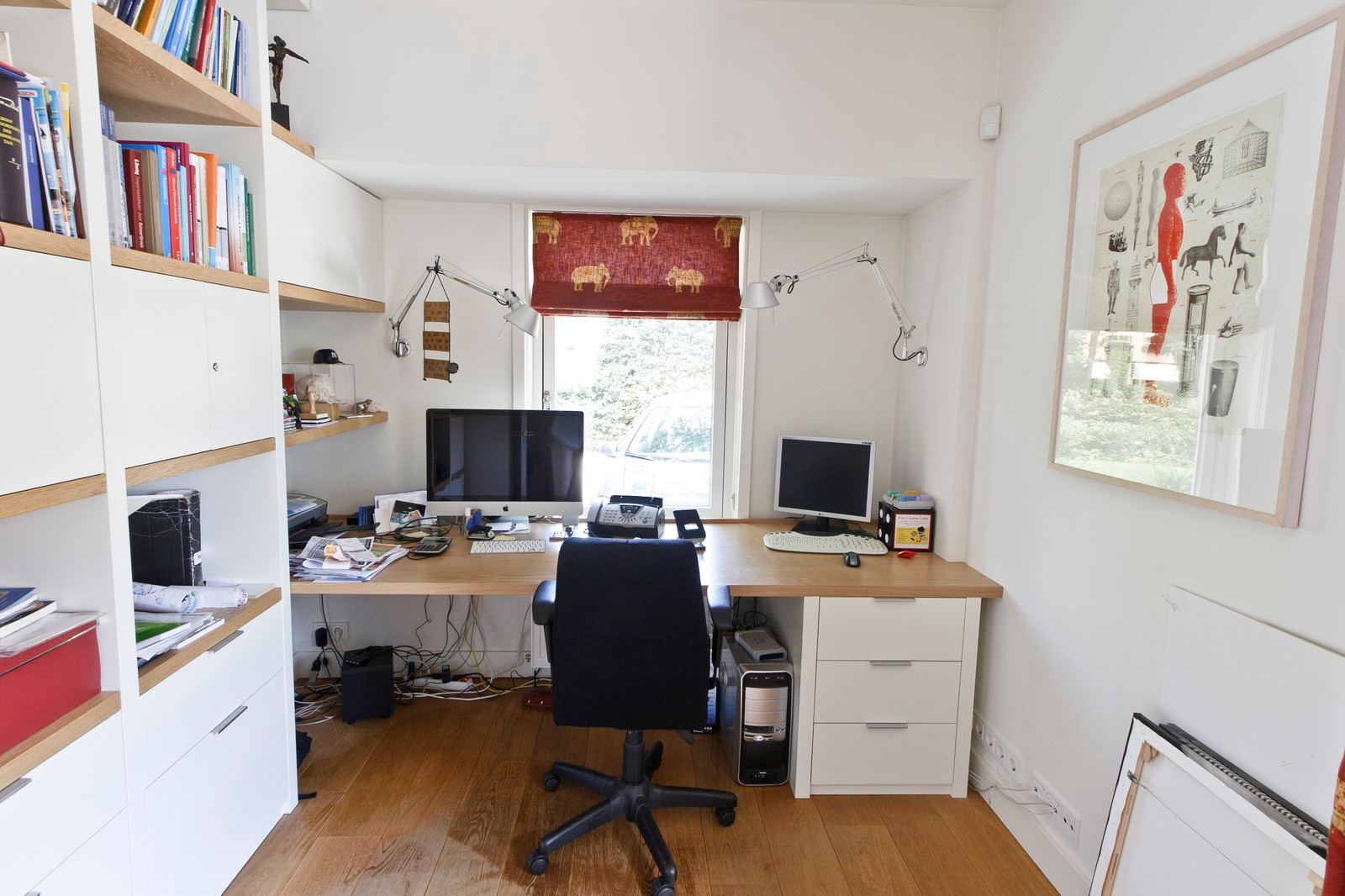 Bureau met eiken blad naast de wandkast met boeken en dozen.