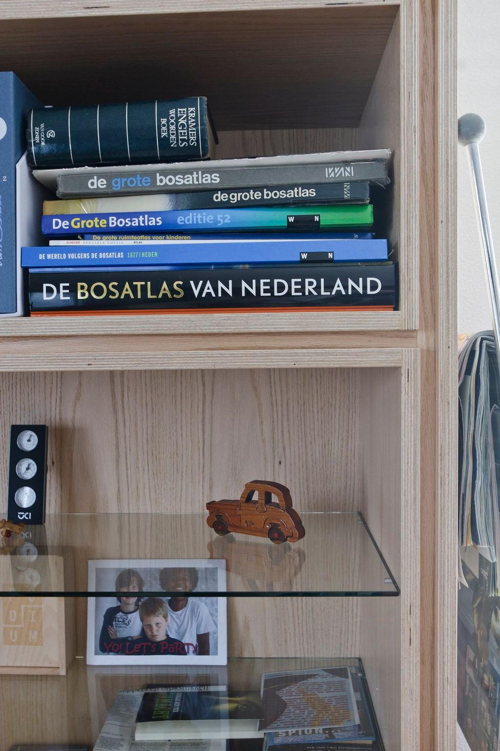 Eikenfineer boekenkast met een glazen legplank eronder.