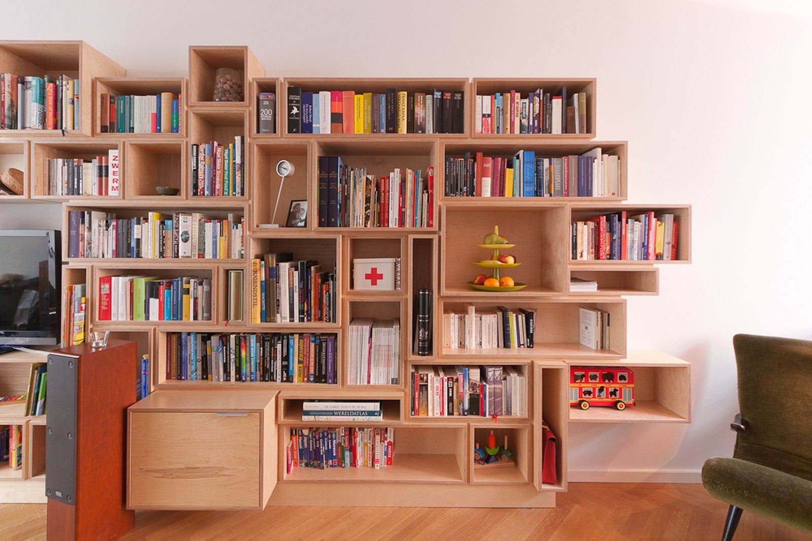 Boekenkast met tientallen verschillende vakken en een ladekast onderin.